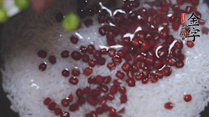 將炒好的食材和大米、紅豆一起放進(jìn)電飯鍋煮。