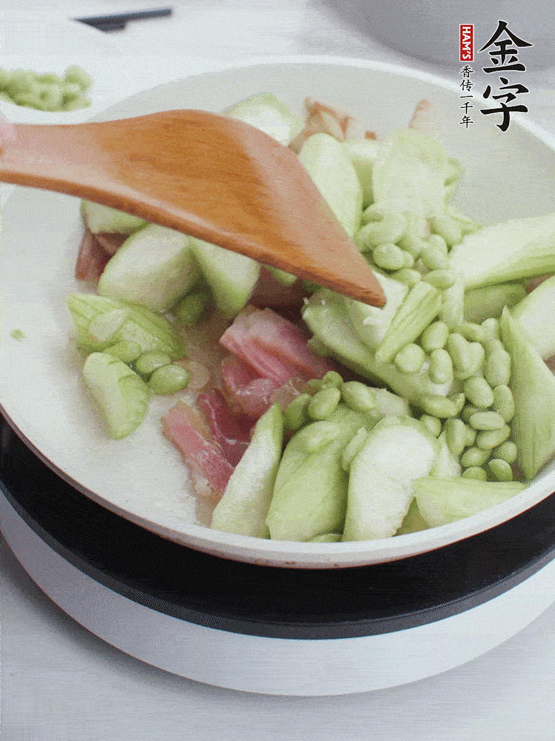 依次下絲瓜、青豆翻炒，炒至絲瓜打蔫縮小。
